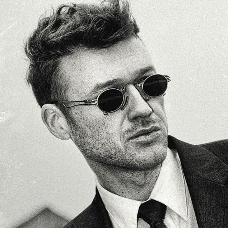 black and white picture of a man wearing steampunk sunglasses