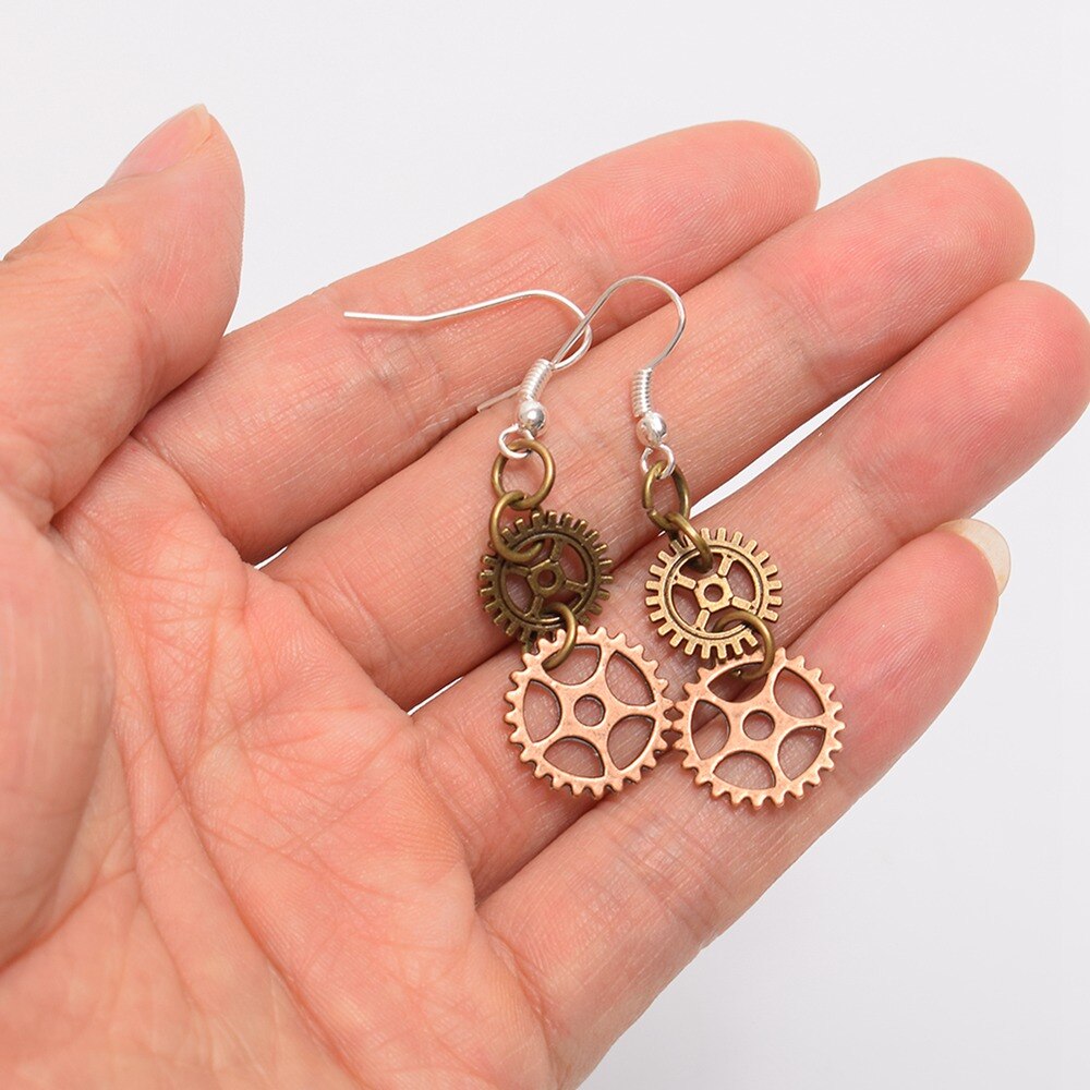 steampunk earrings with two cogs in a hand