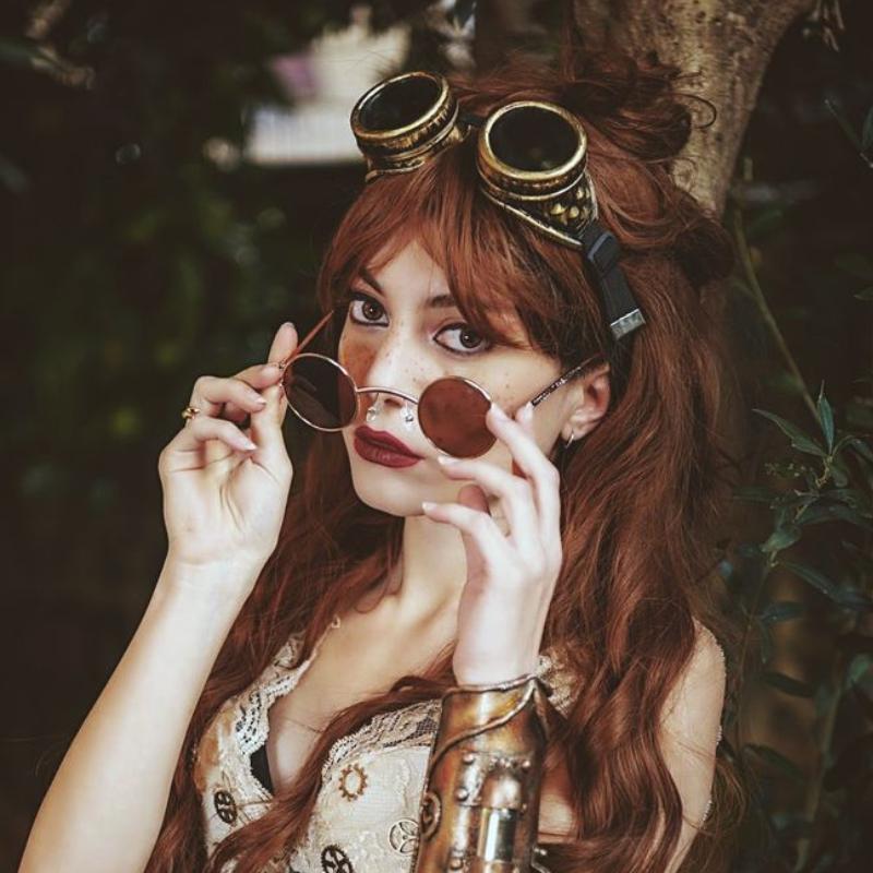 red hair woman wearing steampunk costume goggles on her forehead