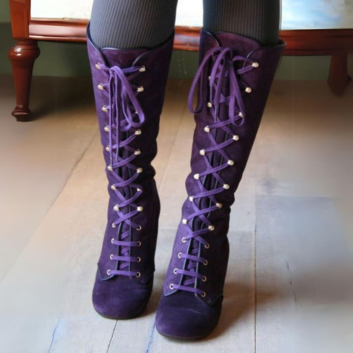 close up of a woman wearing victorian purple boots on a wooden floor 