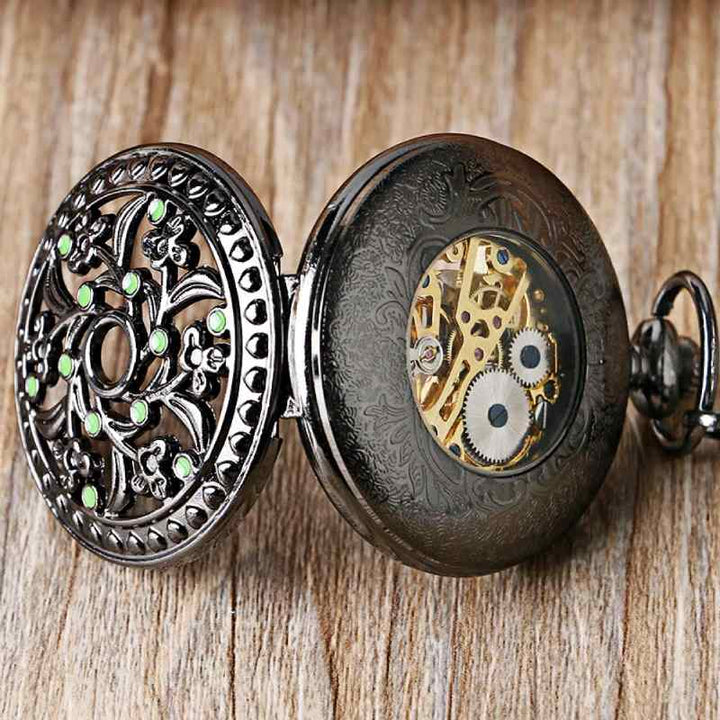 dark pocket watch with green gems